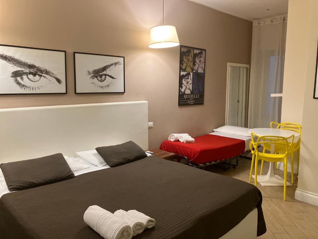 um quarto de hotel com duas camas e uma mesa e cadeiras em dependance22 em Nápoles