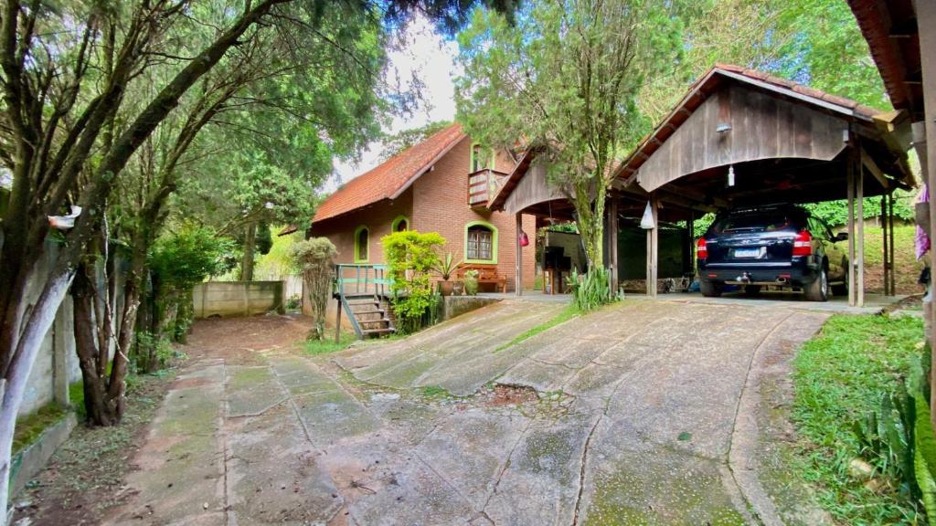 uma casa com um carro estacionado numa garagem em Casa de Campo - Condomínio Arco Íris em Atibaia