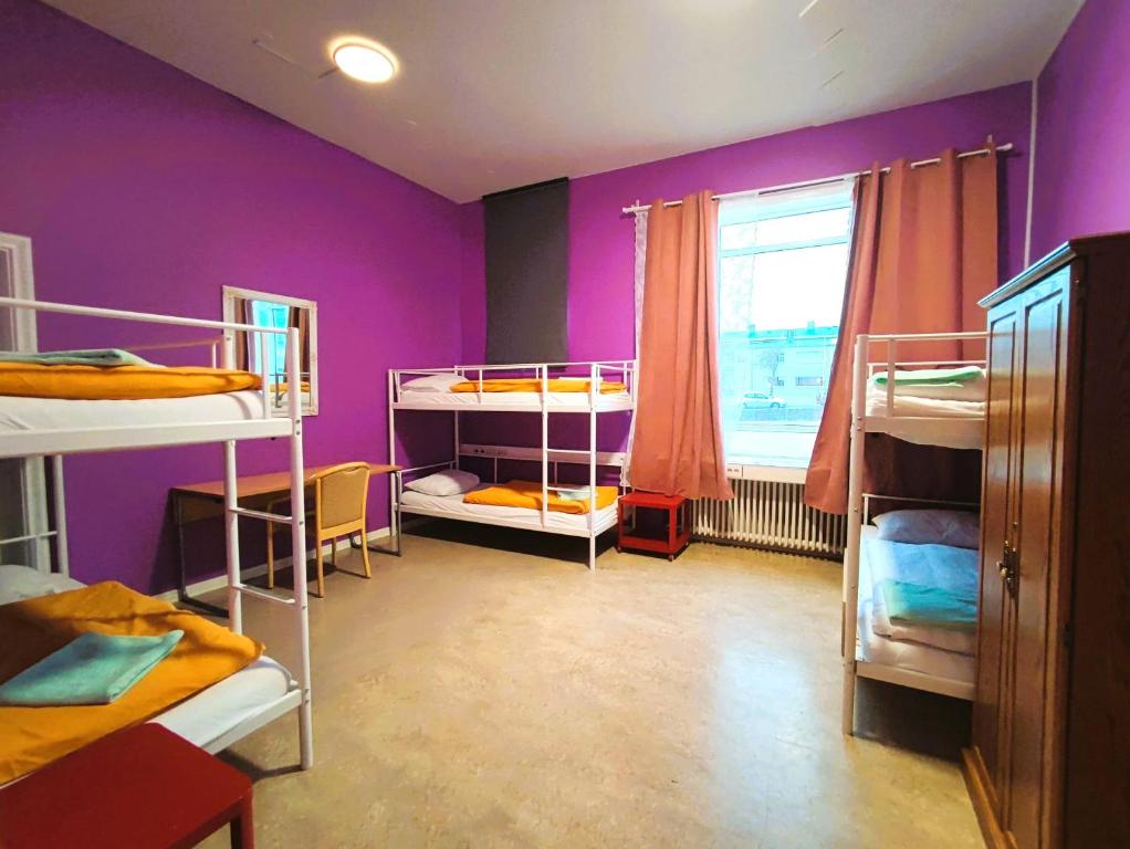 een kamer met 3 stapelbedden en een paarse muur bij Hostel B47 in Reykjavík