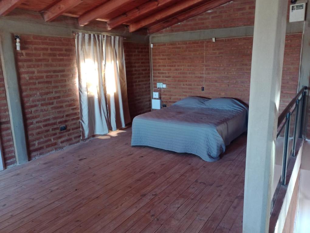 a bedroom with a bed on a wooden deck at Casagrande Centenario in Centenario