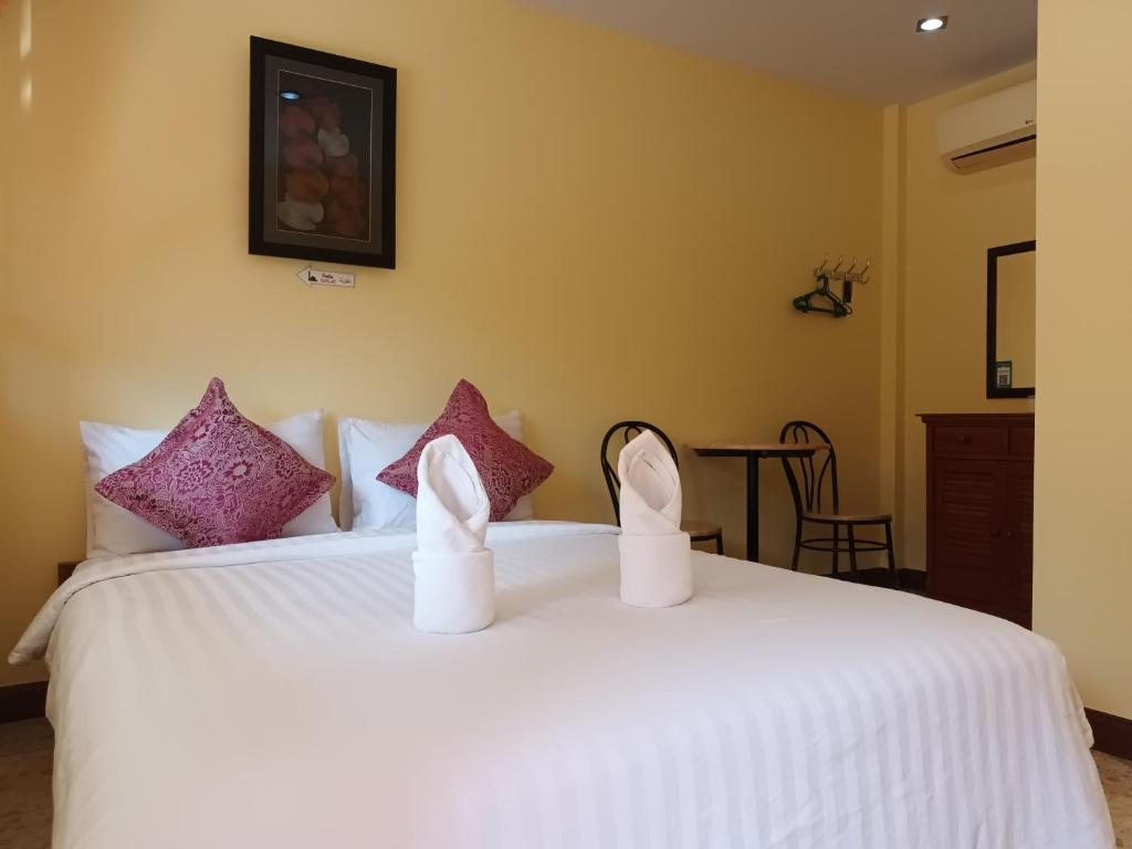 ein Schlafzimmer mit einem Bett mit weißen Schuhen darauf in der Unterkunft Krajomsai Resort เจ้าของมุสลิมห้ามดื่มแอลกอฮอล์ in Ban Pak Ba Ra