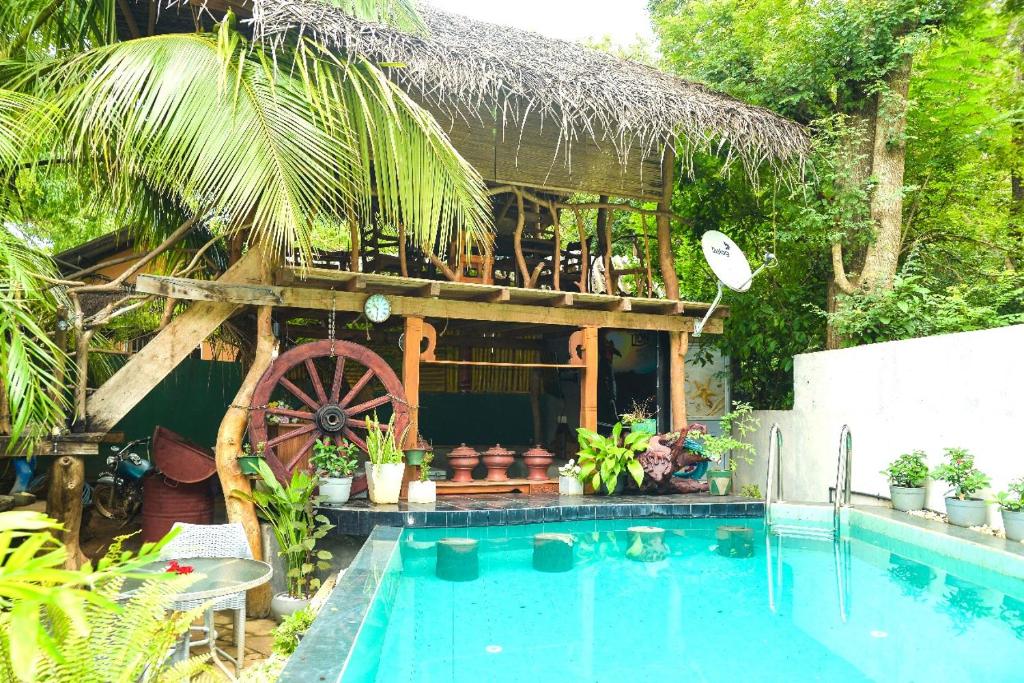 une petite maison avec une piscine en face de celle-ci dans l'établissement VISU VILLA hotel, à Habarana