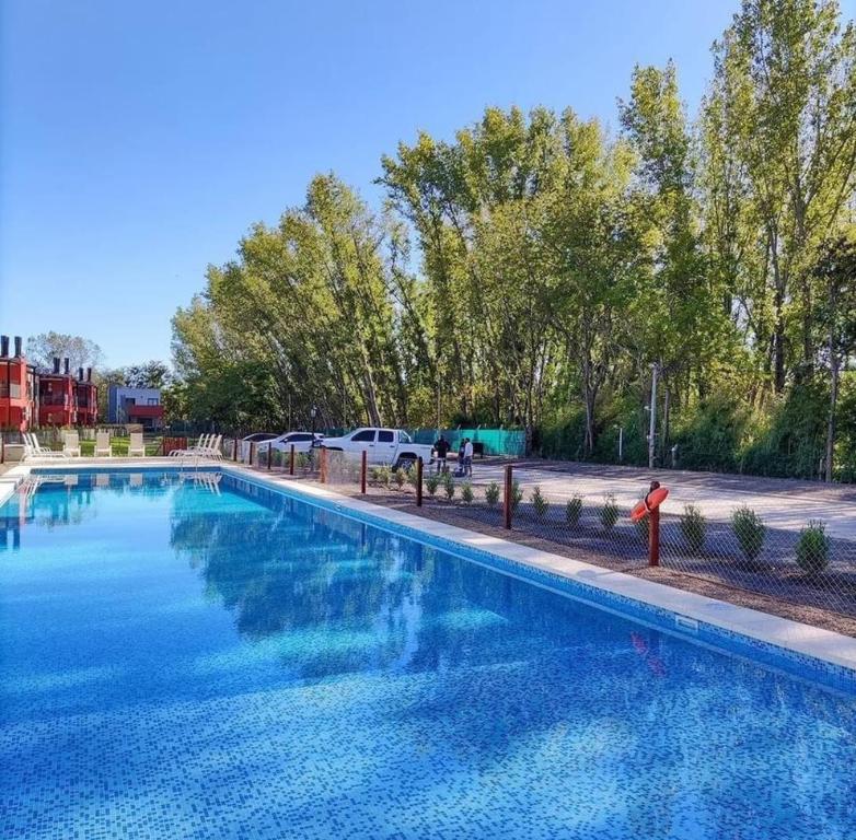 une grande piscine d'eau bleue dans un parc dans l'établissement Altos de la Cañada, à Pilar