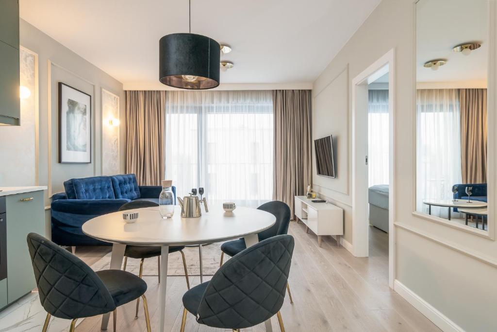 ein Wohnzimmer mit einem Tisch, Stühlen und einem Sofa in der Unterkunft RentPlanet - Apartament Ślężna in Breslau
