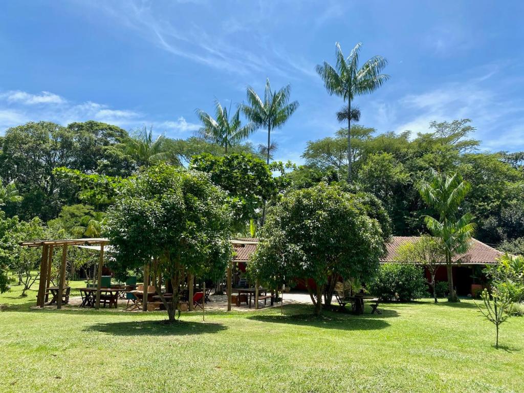 een tuin met een picknicktafel en bomen bij Jardim Mirim in Cananéia