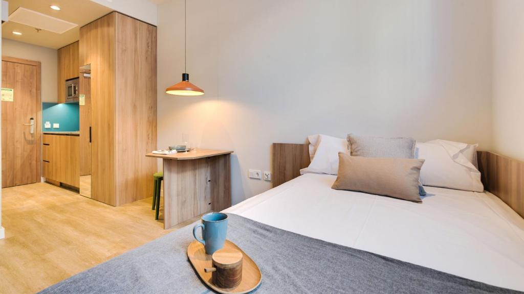 een slaapkamer met een bed en een dienblad bij Livensa Living Studios - Valencia Viveros in Valencia