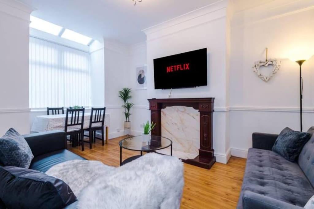 a living room with a couch and a fire place at Spacious 4-Bed House Manchester in Manchester