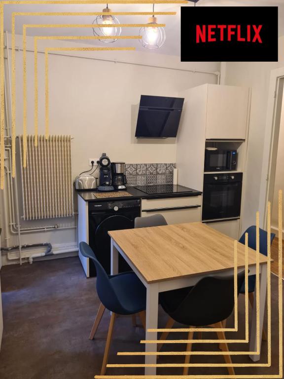 une cuisine avec une table en bois et des chaises bleues dans l'établissement Le Déodatien, à Saint-Dié-des-Vosges