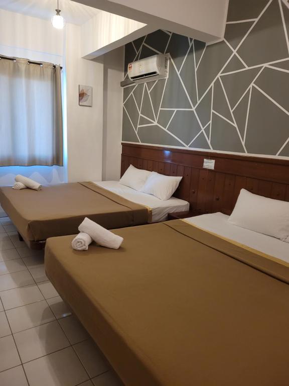 um quarto de hotel com duas camas com toalhas em Pangkor BeachWalk Studio em Ilha de Pangkor