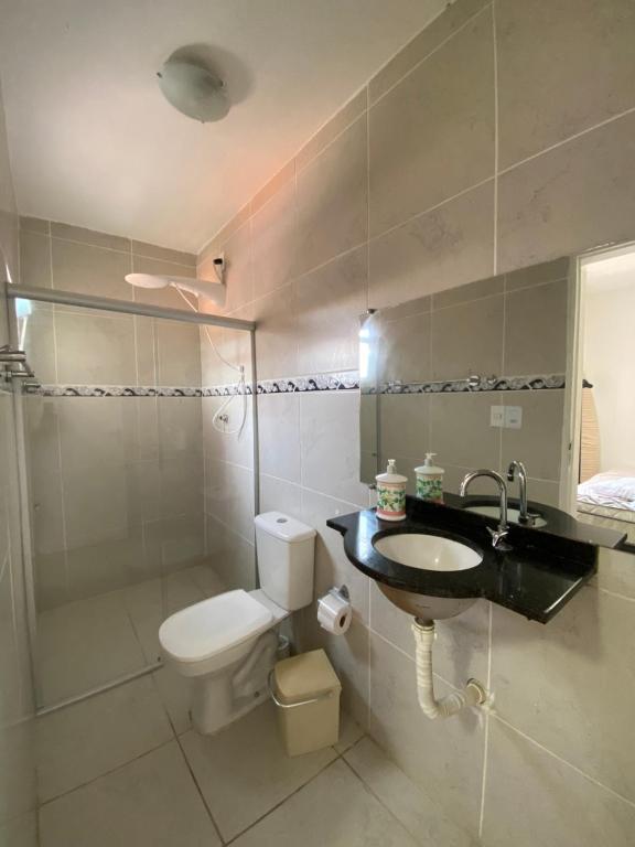 a bathroom with a toilet and a sink and a shower at Casa 90m, dois quartos, próxima às praias in Maceió