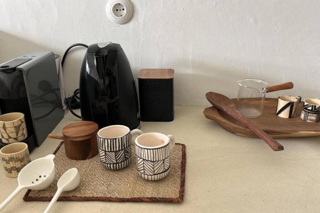 a counter with cups and spoons on a counter top at Casa Olarias in Grândola