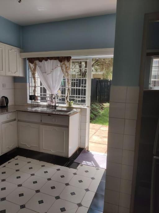 a kitchen with a sink and a window and a counter at Townhouse Upper Hill Nairobi 2 in Nairobi