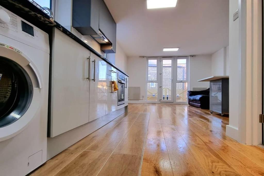 a large living room with a washer and dryer at Brand New Flat Close To Turnpike Lane Tube Station in London