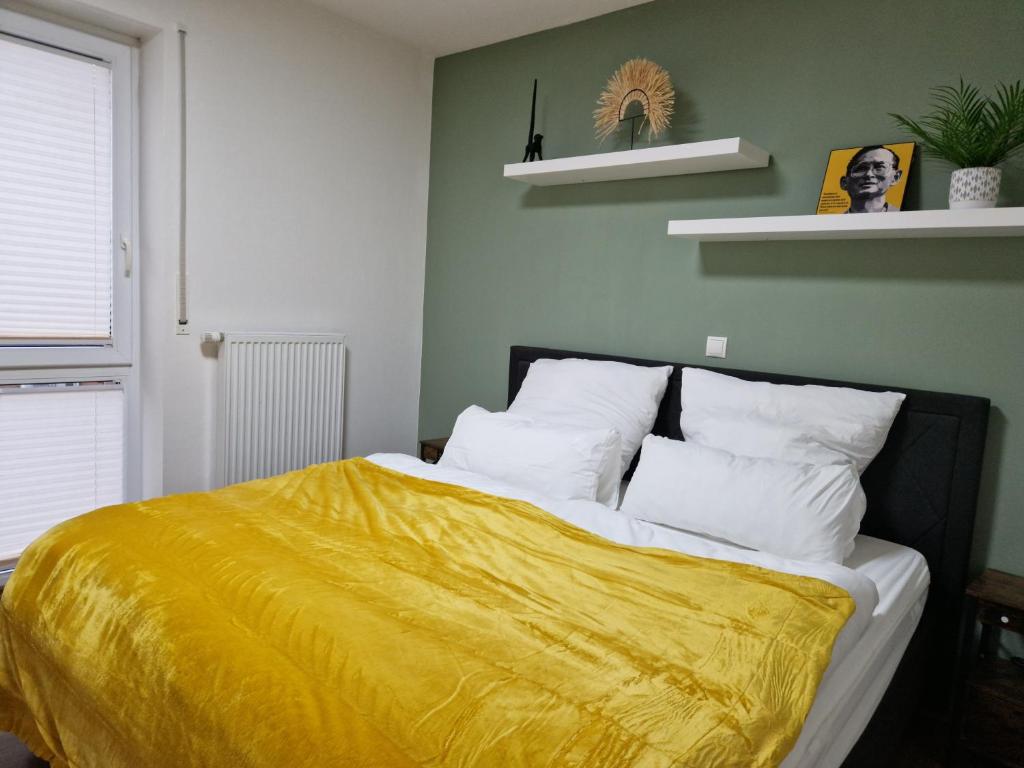 a bedroom with a bed with a yellow blanket at Cozy Apartment: Design Superior Suite Zentral - Küche - Balkon in Cloppenburg