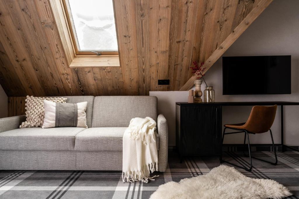uma sala de estar com um sofá e uma televisão em Owce Dwie em Zakopane