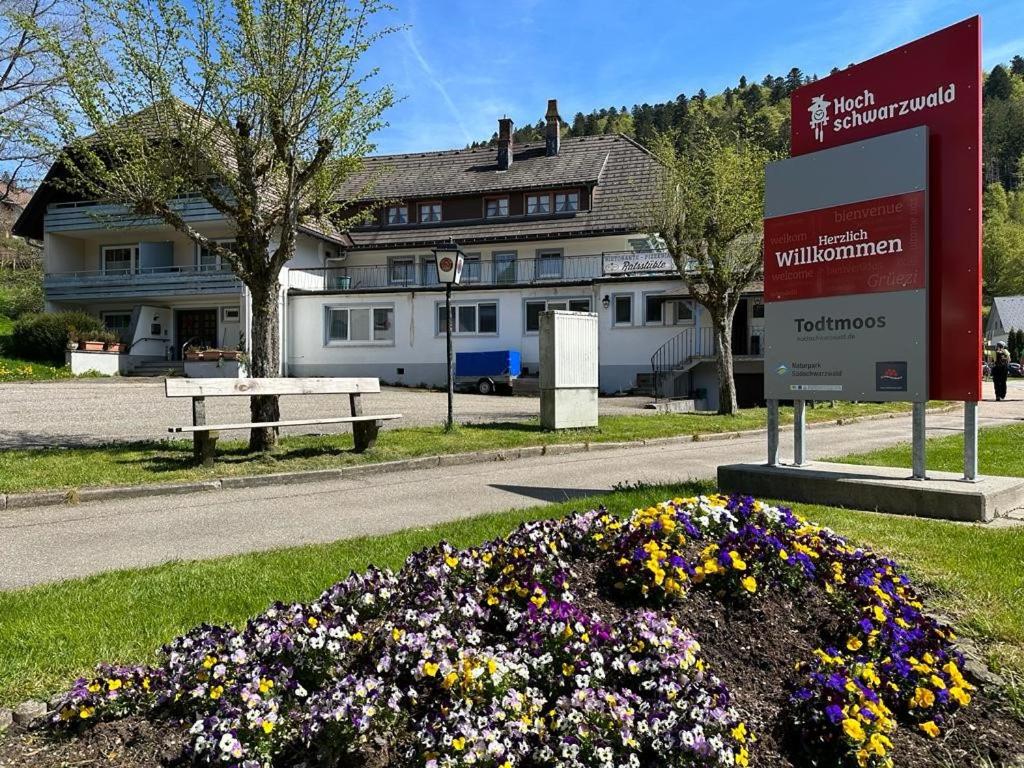 um sinal num canteiro de flores em frente a um edifício em Chalet MOOS em Todtmoos