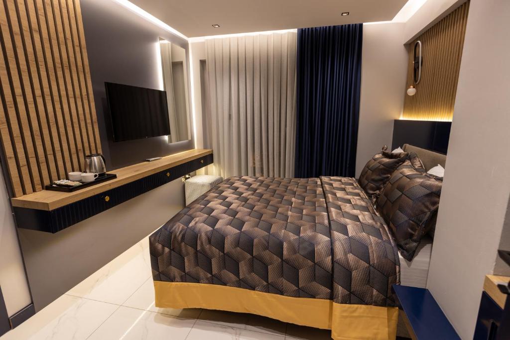 AMASRA DADAYLI HOTEL في أماسرا: غرفة نوم فيها سرير وتلفزيون