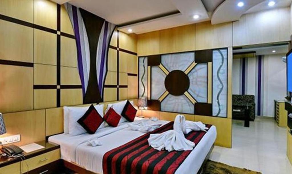 a bedroom with a large bed with a clock on the wall at FabHotel Prime Simna International in Muzaffarpur