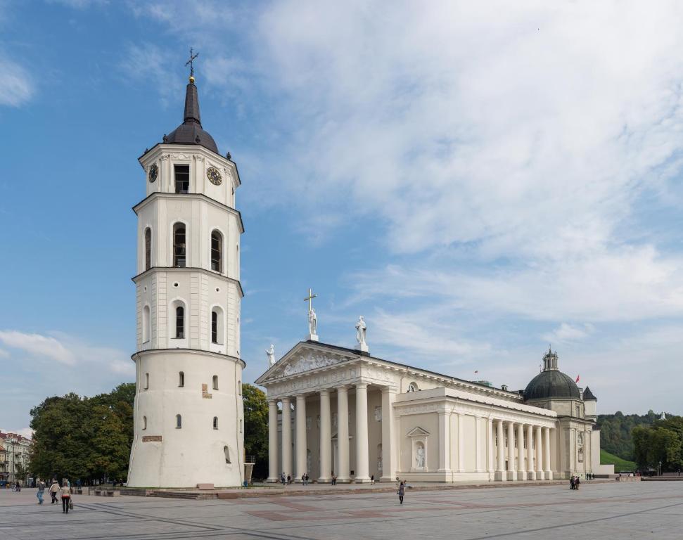 un edificio con una torre dell'orologio davanti di Super apartments in front of the Cathedral Square a Vilnius