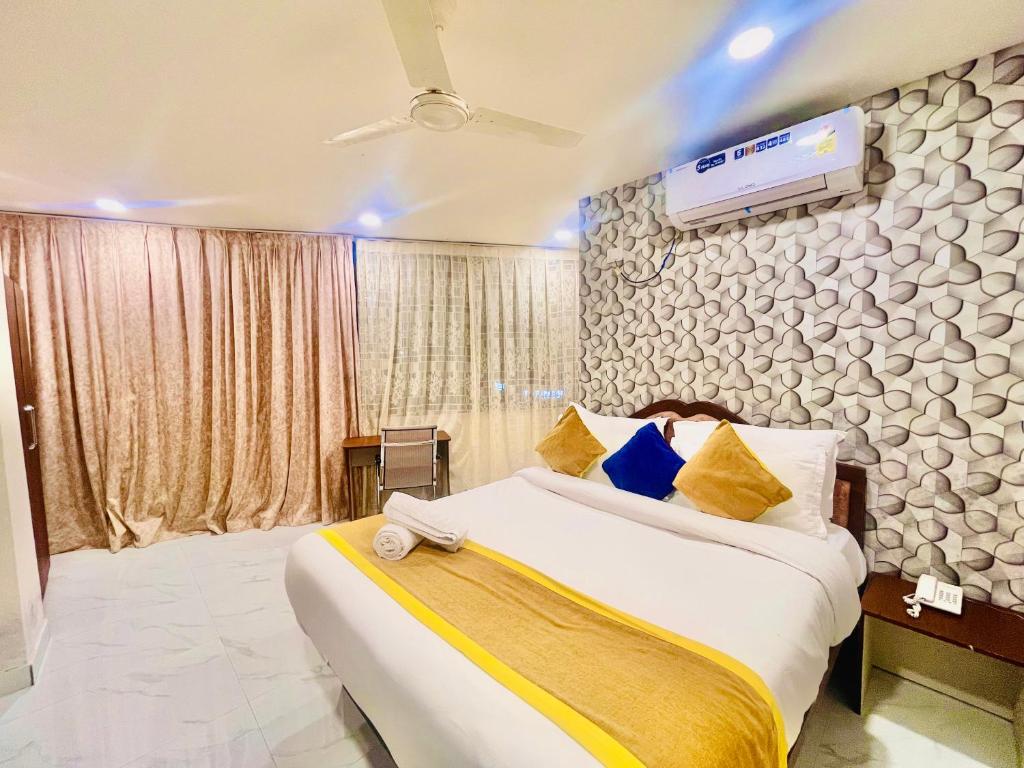 um quarto com uma cama e uma televisão na parede em HOTEL EAGLE GRAND em Shamshabad