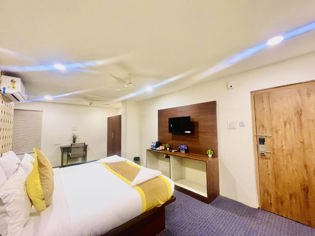 HOTEL EAGLE GRAND في شامشاباد: غرفة في الفندق بسرير وتلفزيون وغرفة