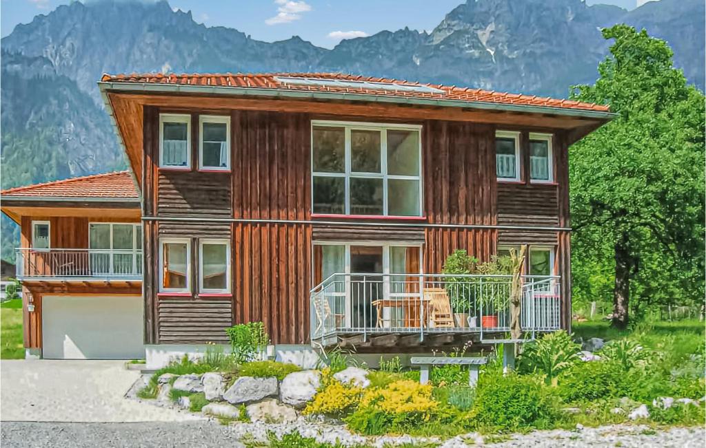 Casa de madera con balcón y montañas de fondo en Gorgeous Apartment In Ausserbraz With Kitchen, en Ausserbraz