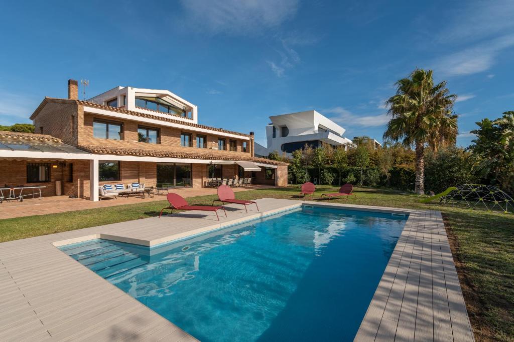 une maison avec une piscine en face d'une maison dans l'établissement Gava Beach Villa by Olala Homes, à Gavà