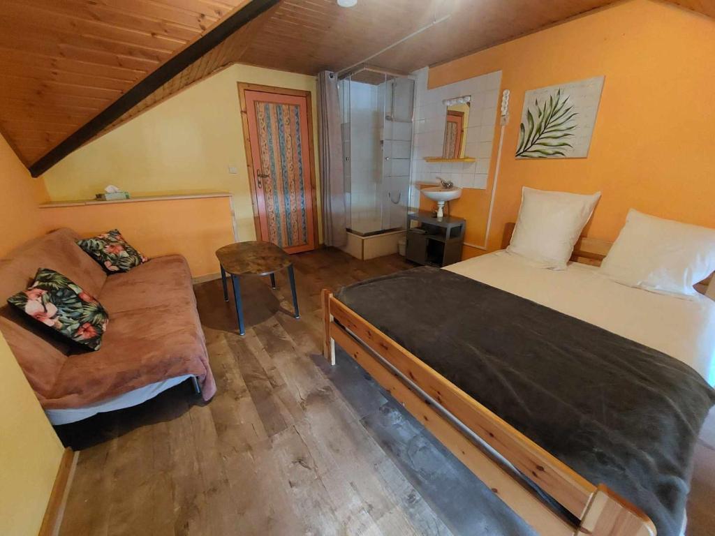 - une chambre avec un grand lit et un canapé dans l'établissement Le Vieux La Roche, à La-Roche-en-Ardenne