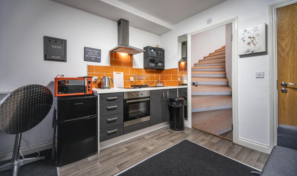 uma cozinha com armários pretos e uma escadaria em ALTIDO Trendy City Centre Studio em Birmingham