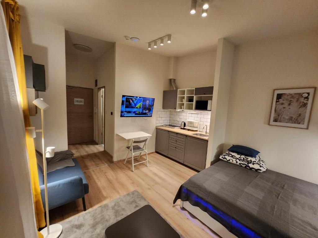 ein kleines Zimmer mit einem Bett und einer Küche in der Unterkunft Apartman 18 in Debrecen