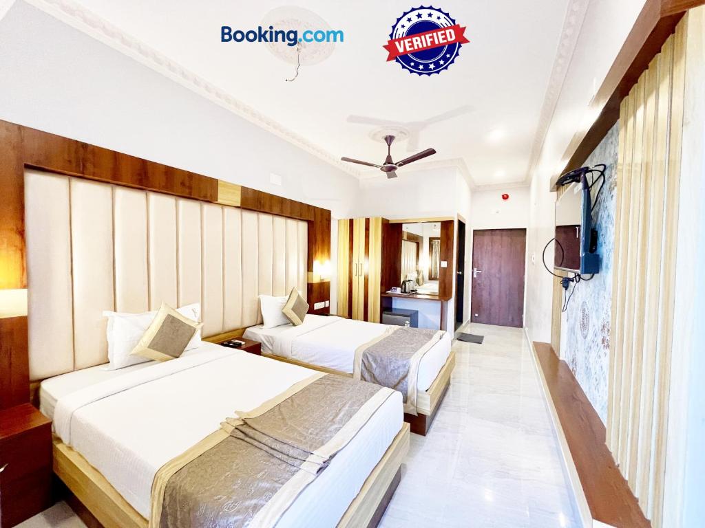 een hotelkamer met 2 bedden en een televisie bij Hotel A One Lagoon ! Puri Swimming-pool, near-sea-beach-and-temple fully-air-conditioned-hotel with-lift-and-parking-facility breakfast-included in Puri