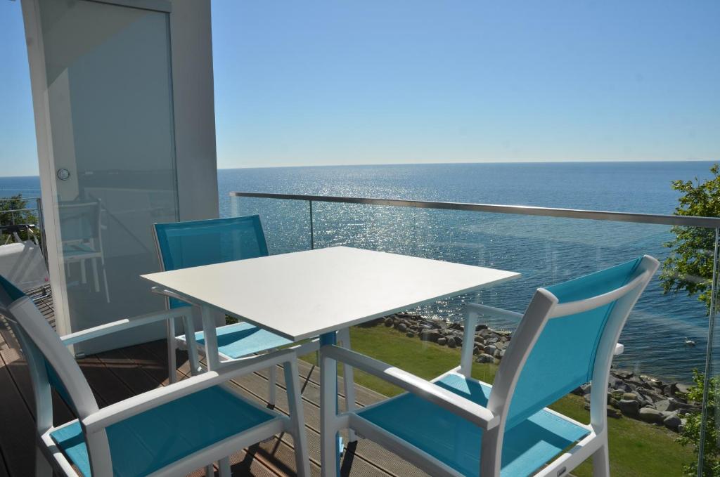 a table and chairs on a balcony with the ocean at Ostseeresidenz Sassnitz - Penthouse 20 mit Sauna, Balkon, Meerblick in Sassnitz