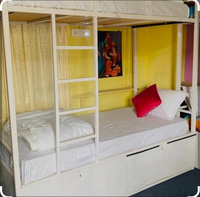 a bunk bed with white shelves and a red pillow at City and Palace view guest House in Udaipur