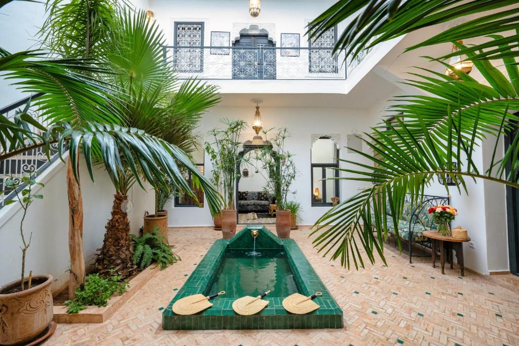 a swimming pool with two surfboards in a room with palm trees at Riad Des Sables-Exclusive -4 Suites -Swimming Pool in Marrakesh
