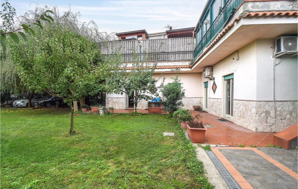 a house with a yard with a tree in front of it at 2 Bedroom Cozy Apartment In Napoli in Naples