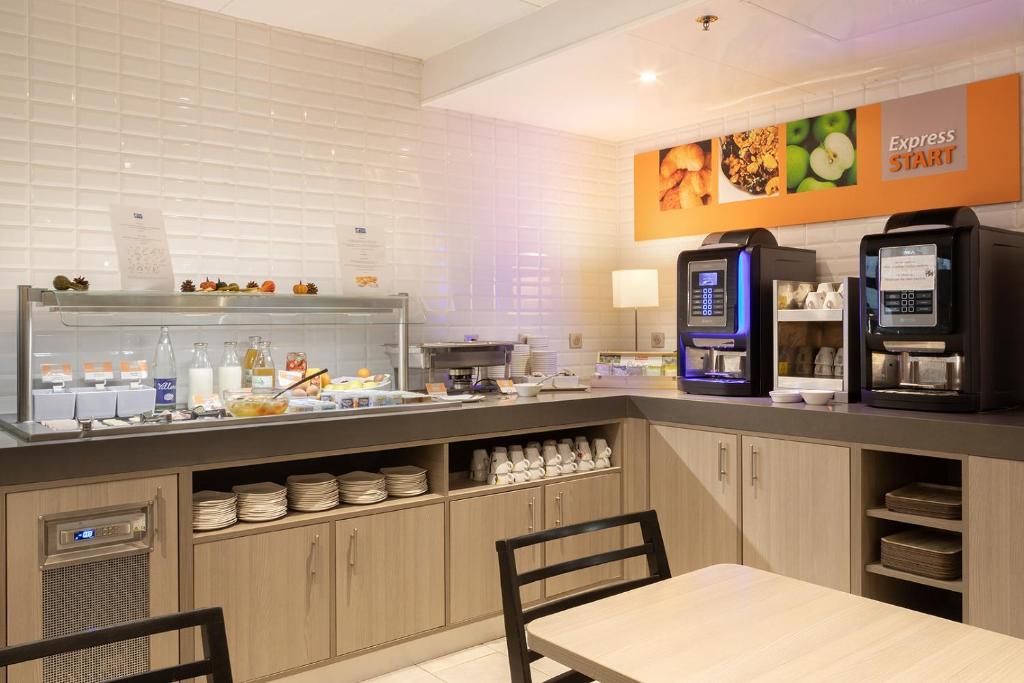a restaurant kitchen with a counter with a coffee maker at Holiday Inn Express Amiens, an IHG Hotel in Amiens