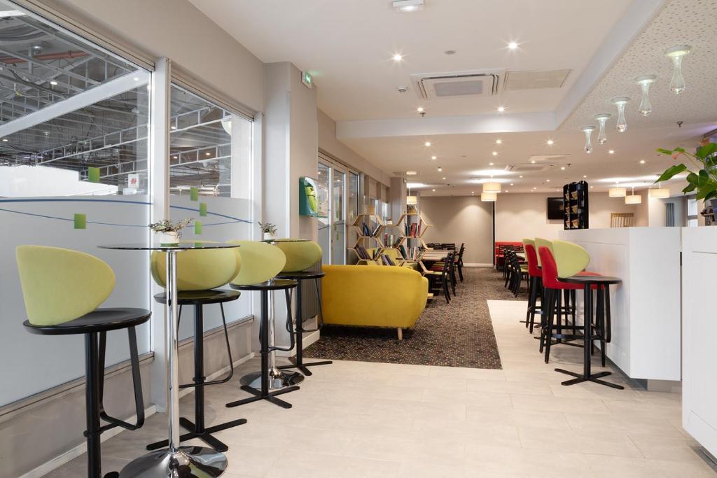 a barber shop with yellow and red chairs at Holiday Inn Express Amiens, an IHG Hotel in Amiens