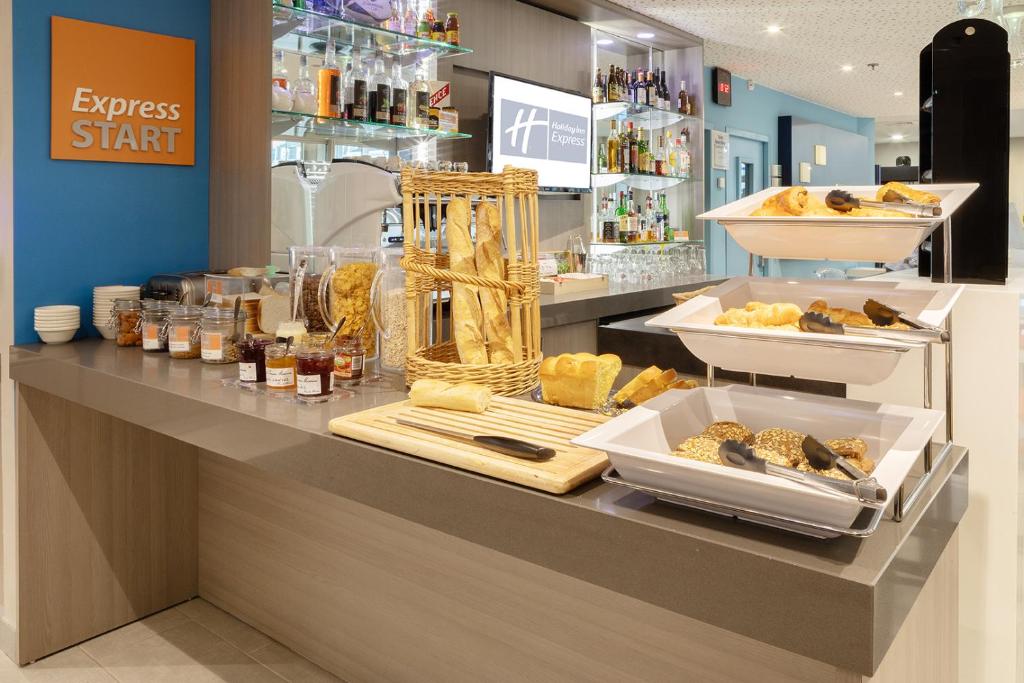 a bakery counter with bread and other food items at Holiday Inn Express Amiens, an IHG Hotel in Amiens