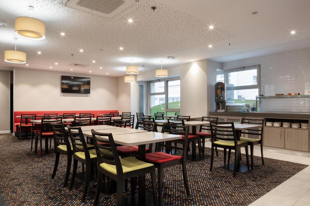 a dining room with tables and chairs at Holiday Inn Express Amiens, an IHG Hotel in Amiens