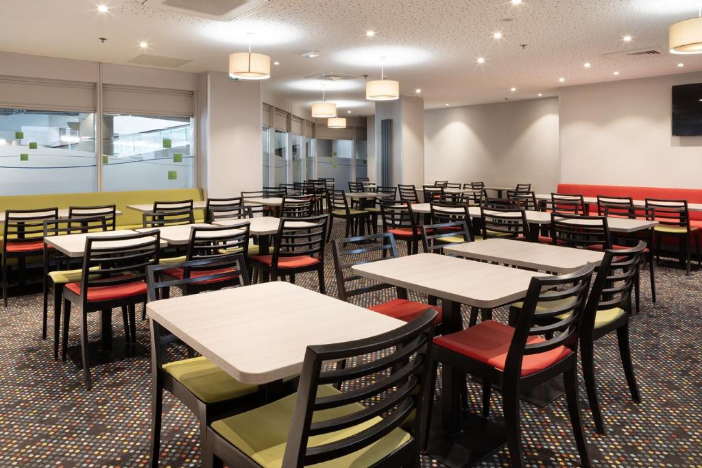an empty dining room with tables and chairs at Holiday Inn Express Amiens, an IHG Hotel in Amiens