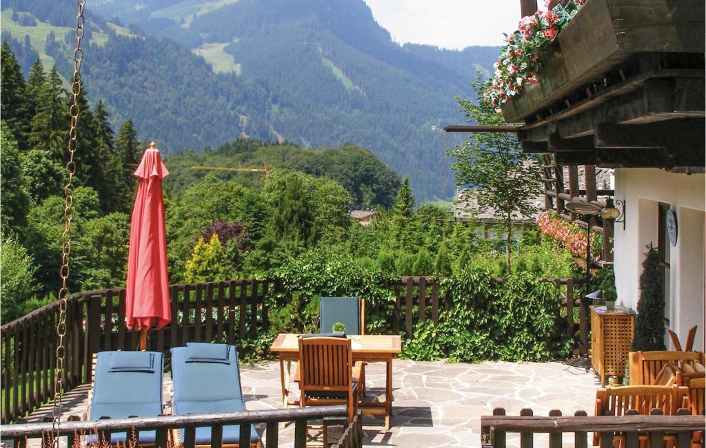 une terrasse avec une table, des chaises et un parasol dans l'établissement Cozy Home In Kitzbhel With House A Mountain View, à Haselwand