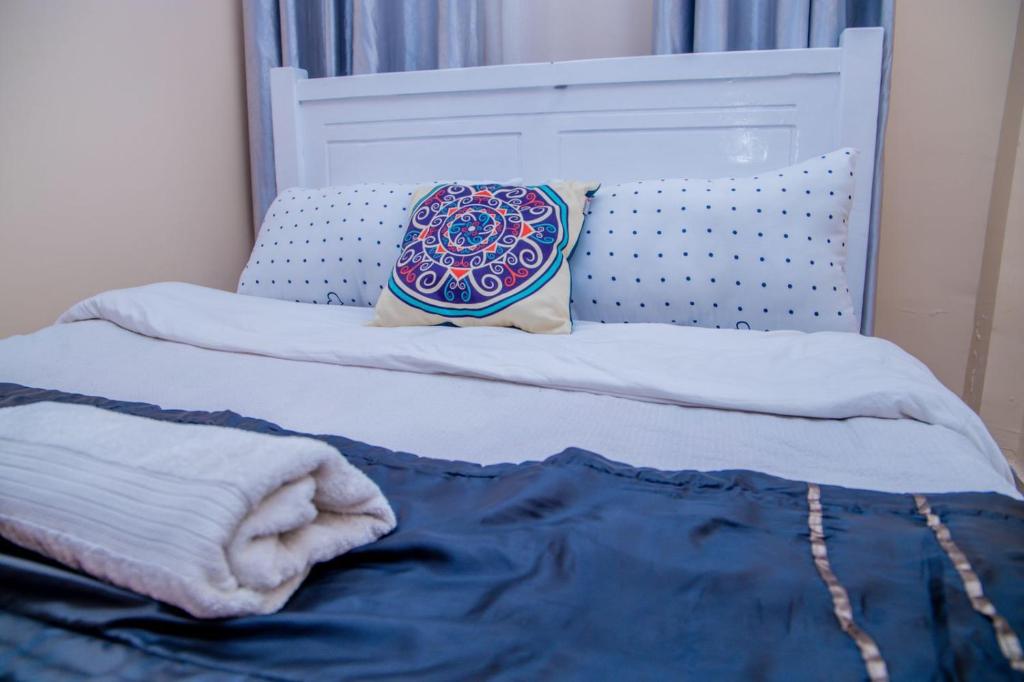 ein Bett mit einem Kissen darüber in der Unterkunft IT IS WELL HOMES in Kisii