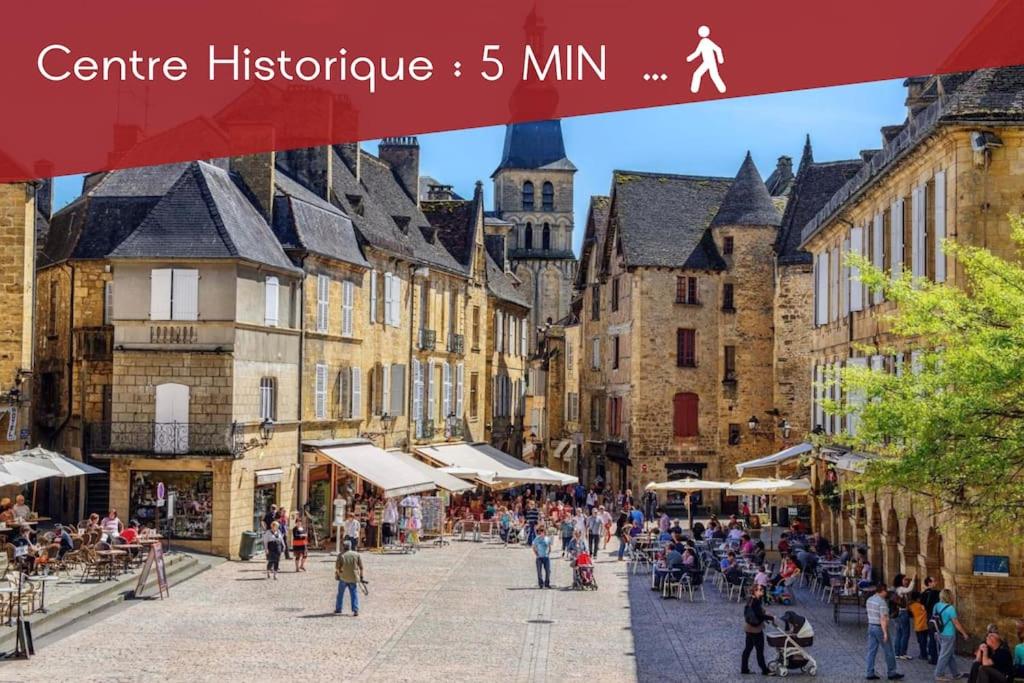 eine Gruppe von Menschen, die eine Straße mit Gebäuden entlanggehen in der Unterkunft Le Spicy 2 minutes centre historique parking in Sarlat-la-Canéda