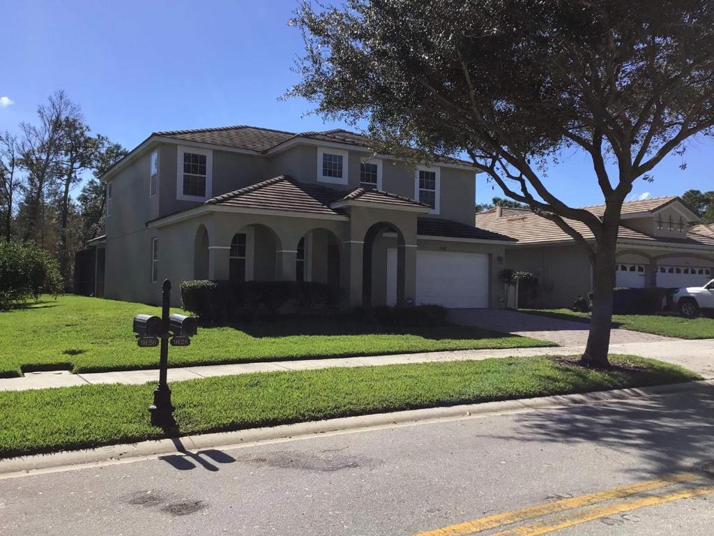 a house with a parking meter on a street at South Facing Pool Near Disney 5 Bed Luxury in Kissimmee