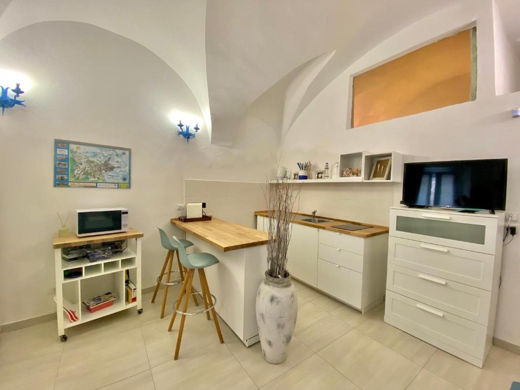 a kitchen with a desk and a tv and a vase at Casa Tua - Sea View Chianca in Vieste