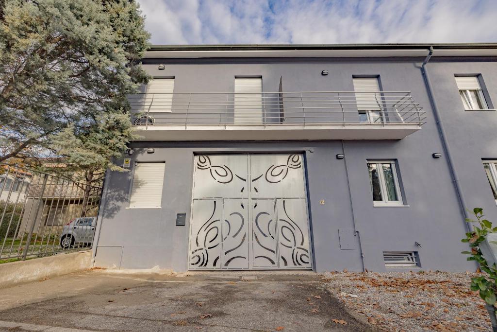 Casa blanca con una gran puerta de garaje en Soggiorni al casolare Apartment by Rhospitality it, en Pregnana Milanese