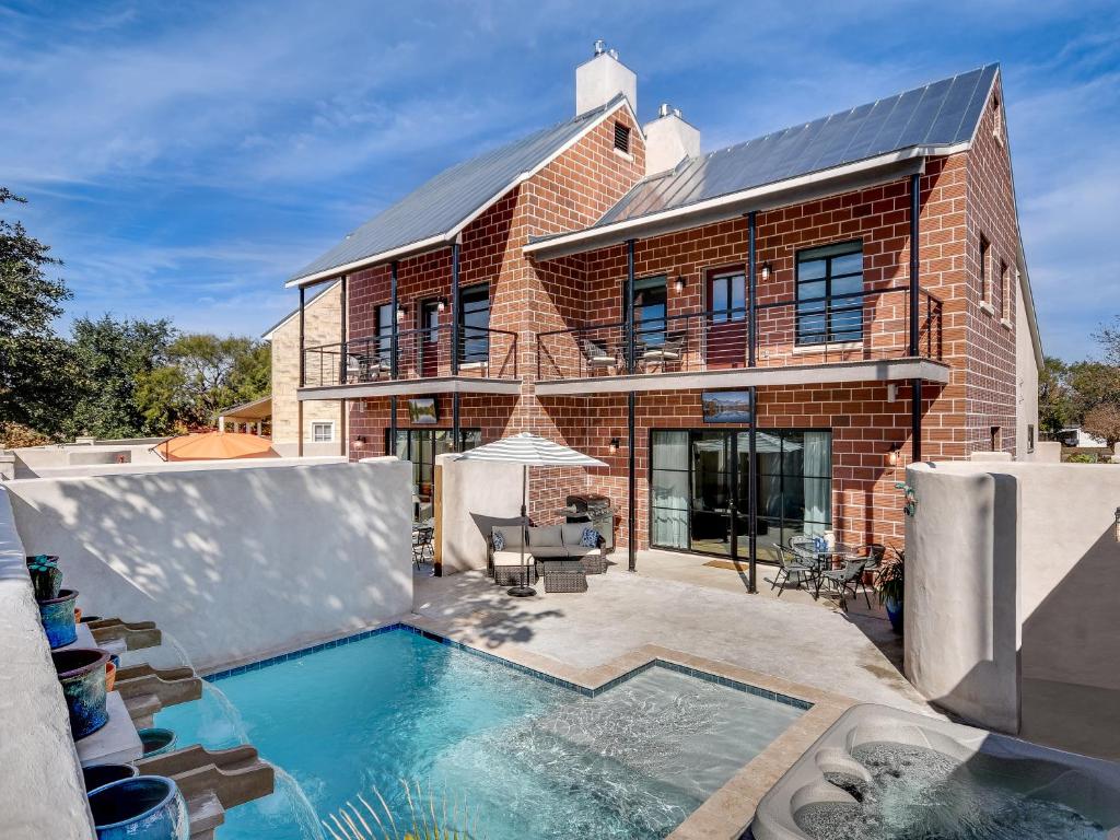 a brick house with a swimming pool in front of it at GARDENS OF BARONS CREEK UNIT A in Fredericksburg