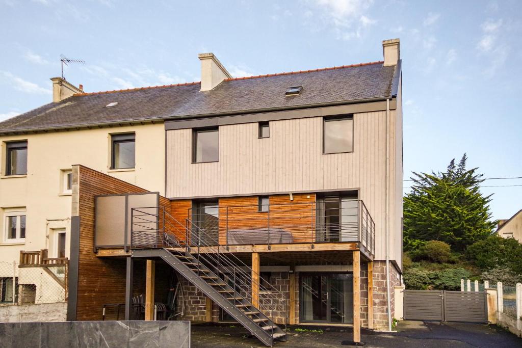 une grande maison avec un escalier en face de celle-ci dans l'établissement Le Galion - Maison avec terrasses proche plage, à Pléneuf-Val-André