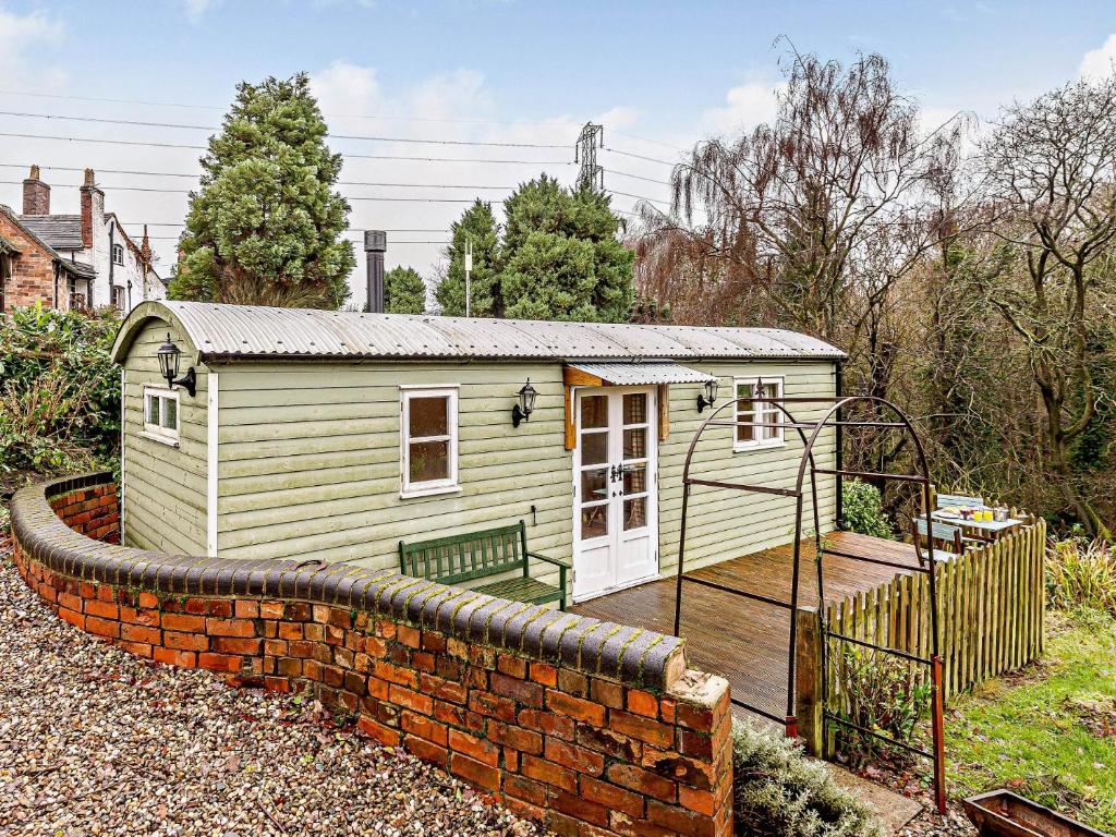 a small yellow house with a brick wall at 1 Bed in Ironbridge 80727 in Leighton