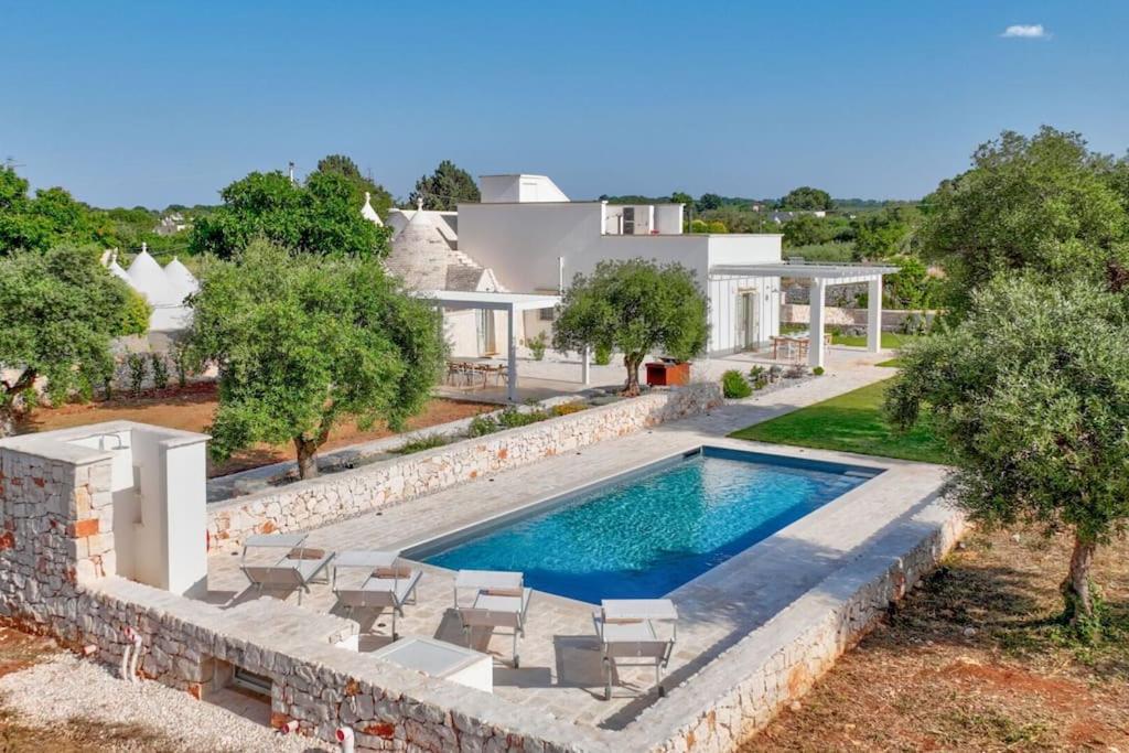 une vue aérienne d'une maison avec piscine dans l'établissement Trullo Under The Apulian Sky By Raro Villas, à Martina Franca